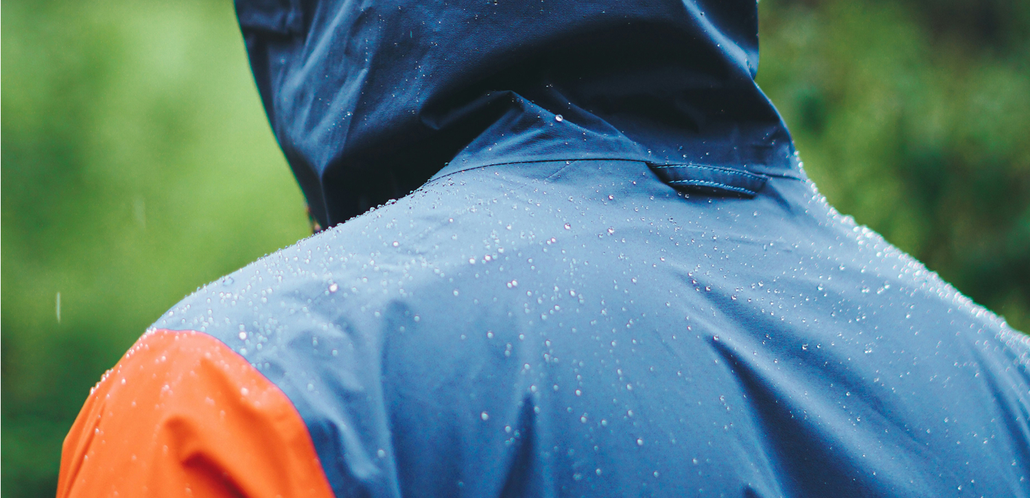 Zoomed in image of a persons back wearing a blue and orange rain jacket